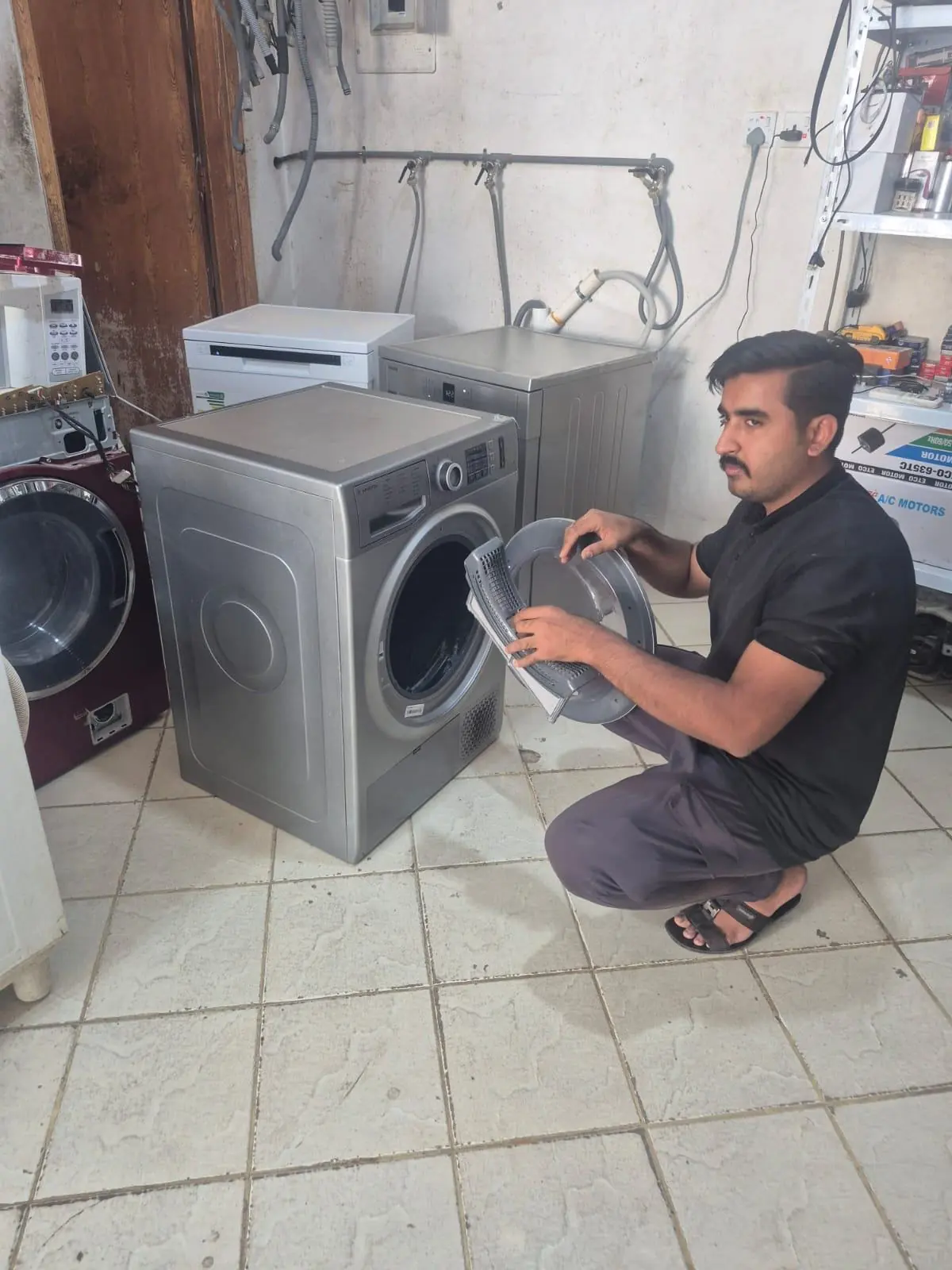 Technician checking a front-load machine in the workshop