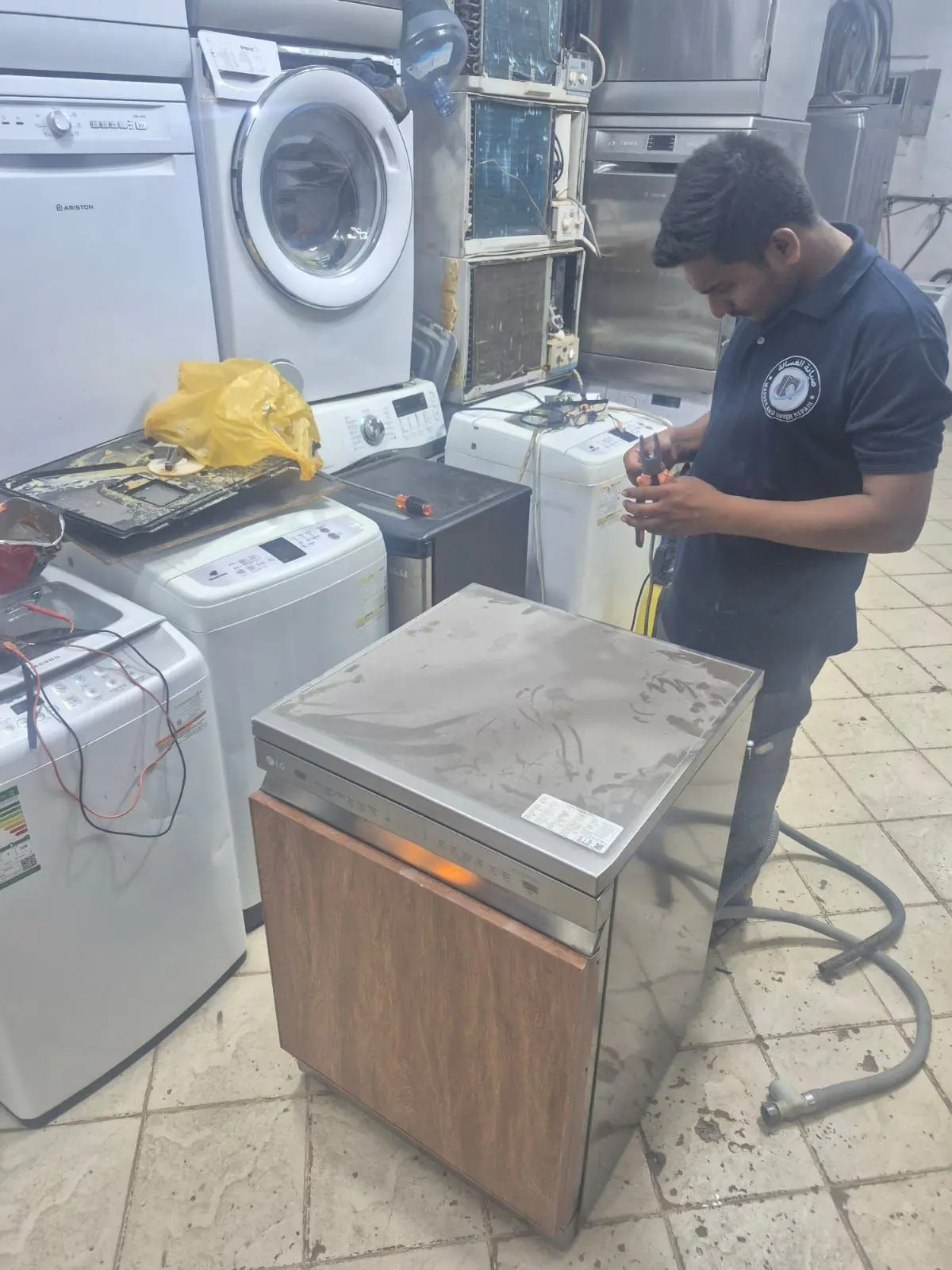 Technician repairing a home appliance in the workshop